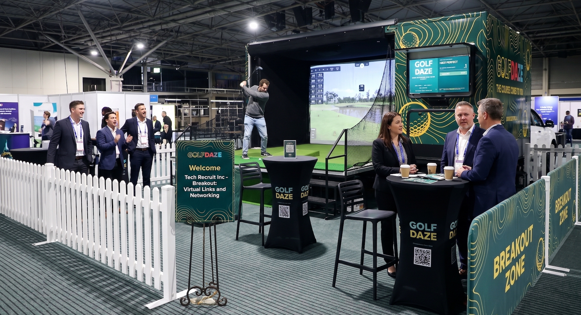 Golf Daze simulator running as a branded breakout zone on a conference expo floor, with delegates networking around it